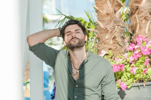 緑のシャツを着たハンサムな男 観光熱帯都市の風景に対する屋外の写真 — ストック写真