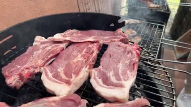 4K, domuz pirzolası, sosis, köfte ve bir evin bahçesinde ızgara. Şef lezzetli ızgara etle barbekü yapıyor..