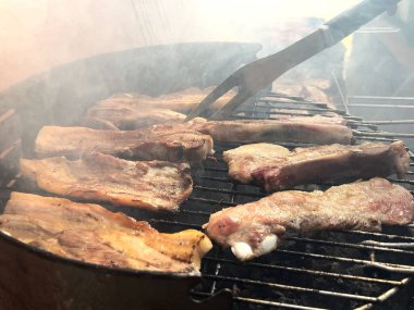 BBQ with ribs pork, sausage, meatballs, grill in the garden of a house. Chef cooking barbecue with delicious grilled meat