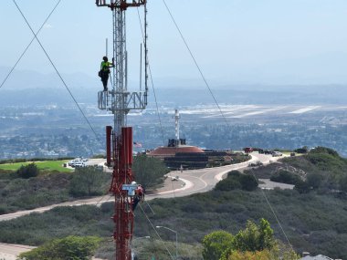 Telekom iletişimi bakımı için yüksek kulede güvenlik ekipmanlarıyla çalışan bir mühendis. San Diego, Güney Kaliforniya, ABD. 21 Eylül 2022