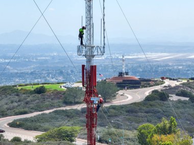 Telekom iletişimi bakımı için yüksek kulede güvenlik ekipmanlarıyla çalışan bir mühendis. San Diego, Güney Kaliforniya, ABD. 21 Eylül 2022
