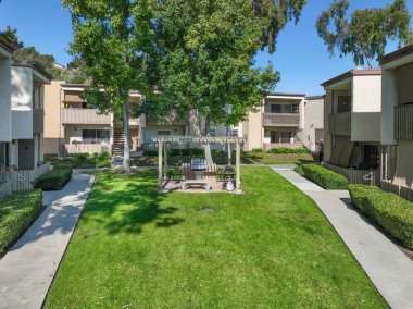 San Diego, California, ABD 'deki tipik apartman kompleksi boyunca yol boyunca bahçe ve çimenler. 1 Ocak 2024