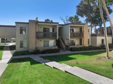 San Diego, California, ABD 'deki tipik apartman kompleksi boyunca yol boyunca bahçe ve çimenler. 1 Ocak 2024