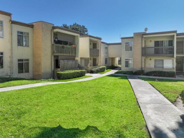 San Diego, California, ABD 'deki tipik apartman kompleksi boyunca yol boyunca bahçe ve çimenler. 1 Ocak 2024