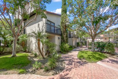 Beton yolu olan apartmanlar ve Carlsbad, San Diego, ABD 'de ağaçları olan bahçeler. 26 Haziran 2025