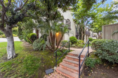 Beton yolu olan apartmanlar ve Carlsbad, San Diego, ABD 'de ağaçları olan bahçeler. 26 Haziran 2025