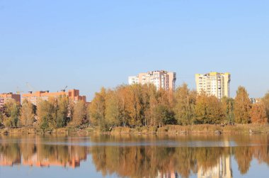 Cheha Gölü 'ndeki çok katlı binaların sonbahar manzarası. Şehir parkında göl manzarası.