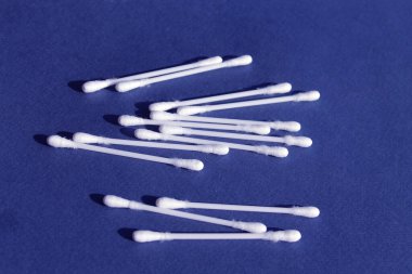 Mavi arka planda pamuklu çubuklar. Üst görünüm kulak çubukları