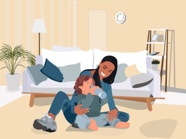 Anne, o evde yerde oturmuş plastik şişeden su içerken oğluna bakıyor..