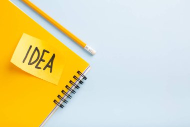 Sarı not defteri fikri, mavi arka planda bir kalem, metin için yer. Yüksek kalite fotoğraf