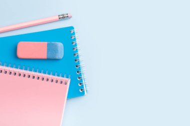 Mavi arka planda pembe, mavi not defteri ve kalem. Mesajın için yer aç. Yüksek kalite fotoğraf