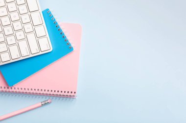 Mavi arka planda pembe, mavi not defteri ve kalem. Mesajın için yer aç. Yüksek kalite fotoğraf