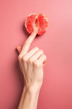 A woman is holding a grapefruit by her panties. Concept masturbation. High quality photo