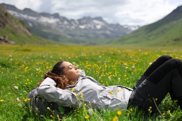 高い山の谷に草の上に横たわるハイカー — ストック写真