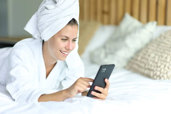 Šťastná Teen Sprchování Ručníkem Přes Hlavu Pomocí Mobilního Telefonu Posteli — Stock fotografie