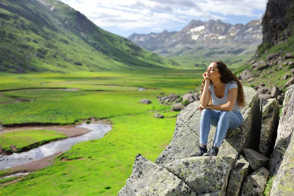 山の中の岩の上に腰を落ち着けて自然を楽しむ女 — ストック写真