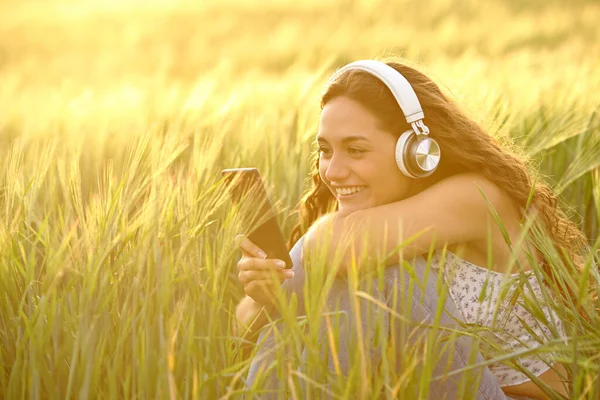 Щаслива Жінка Заході Сонця Навушниках Слухають Музику Смартфона Пшеничному Полі — стокове фото
