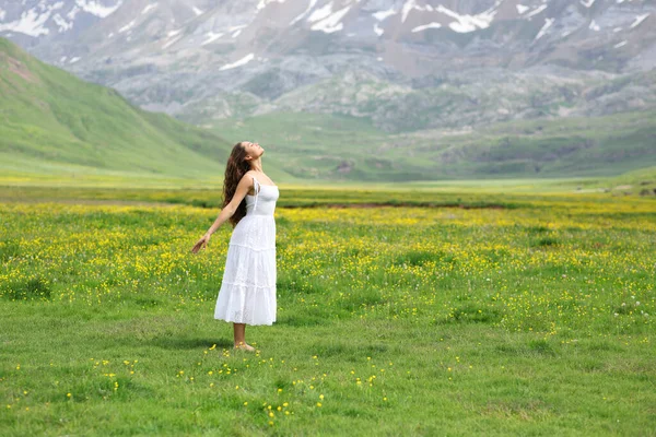 stock image Side view portrait of a woman with white dress breathing fresh air in the mountain