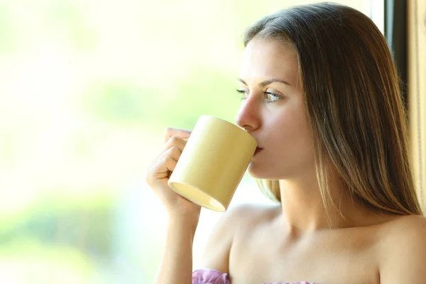 Distraherad Tonåring Dricka Kaffe Tittar Genom Fönstret Hemma — Stockfoto