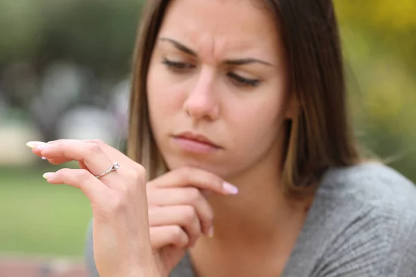 公園で婚約指輪を見て疑問に思う若い女性 — ストック写真
