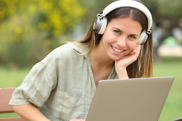Szczęśliwy Nastolatek Słuchawkami Laptopem Patrzy Ciebie Parku — Zdjęcie stockowe