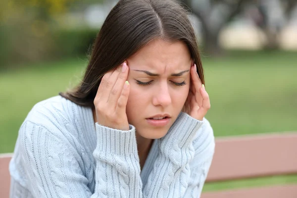 Nastolatek Cierpiący Ból Głowy Narzekający Siedząc Parku — Zdjęcie stockowe
