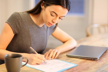 İş kadını ofisteki masada form dolduruyor.