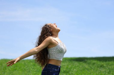 Profile of a happy woman screaming in a field