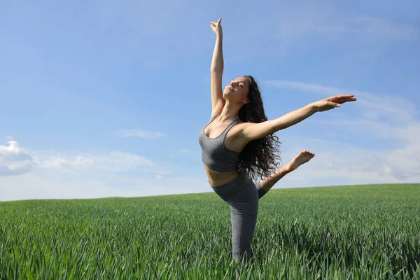 Woman dancing in a green wheat field