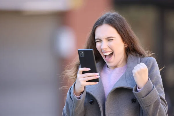 Aufgeregte Frau Feiert Frohe Botschaft Mit Handy Auf Der Straße — Stockfoto