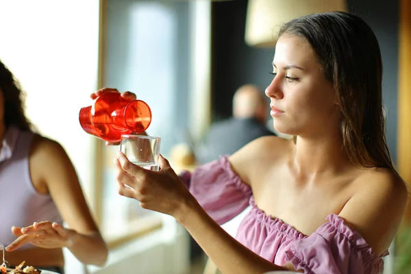 Жінка Наповнює Склянку Водою Сидячи Ресторані — стокове фото