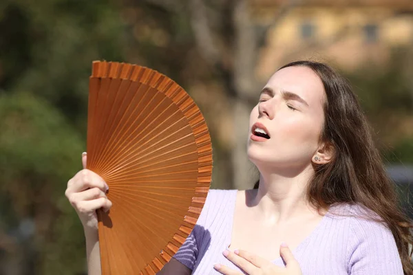 公園で熱中症やファンニングを患っている夏の女性 — ストック写真