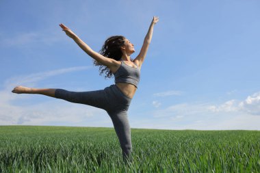 Yeşil bir tarlada uzanan mutlu bir kadın