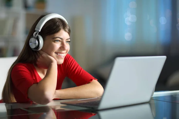 Szczęśliwy Nastolatek Słuchawkami Nocy Przy Użyciu Laptopa Domu — Zdjęcie stockowe