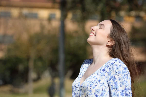 一个快乐女人在公园里呼吸新鲜空气的侧景画像 — 图库照片