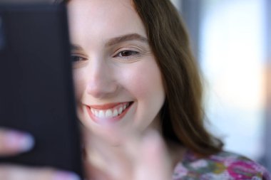 Sokakta telefonu kullanan mutlu bir kadına yaklaş.