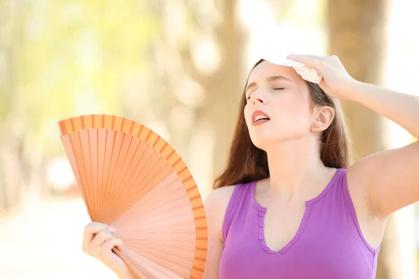 紧张的女人用纸巾擦干汗珠 在炎热的夏日里张大嘴 — 图库照片