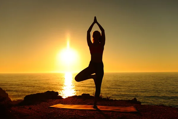 日落时分在海滩上做瑜伽运动的瑜伽运动员的轮廓 — 图库照片
