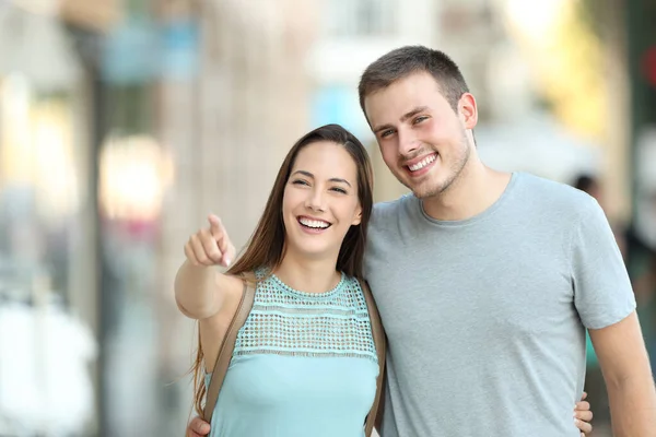 一对快乐的夫妇指着街上某样东西的正面画像 — 图库照片
