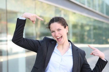 Front view portrait of a proud executive pointing herself in the street clipart