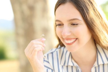 Mutlu nişanlı doğadaki nişan yüzüğüne bakmaktan zevk alıyor.