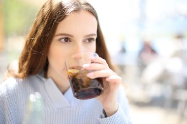 Restoran müşterisi terasta soda içiyor.