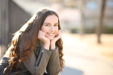 Caddede kameraya bakan mutlu kadın.