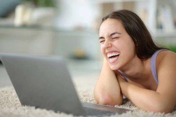 Szczęśliwa Kobieta Śmiejąca Się Głośno Oglądając Media Laptopie Leżącym Podłodze — Zdjęcie stockowe
