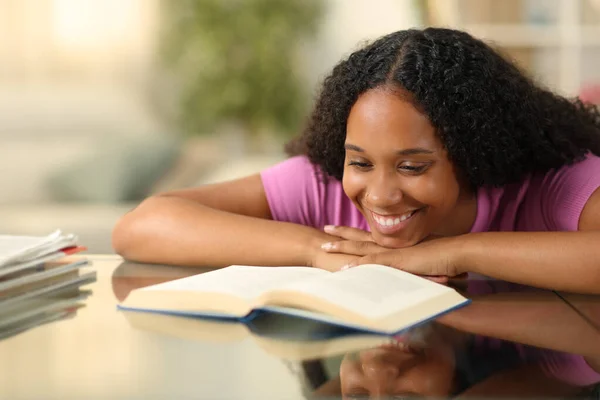 Evdeki Masada Kağıt Kitap Okuyan Mutlu Siyahi Kadın — Stok fotoğraf
