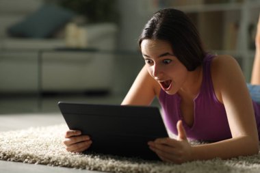 Geceleri evde tablet kullanan hayret verici bir kadın.