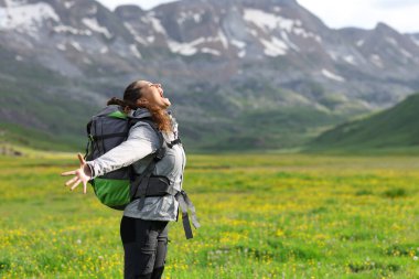 Mutlu bir yürüyüşçünün profili çığlık atıyor ve kollarını doğada açıyor.