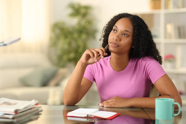 Mujer Negra Pensando Con Agenda Sentada Casa —  Fotos de Stock