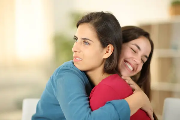 Happy woman hugging a false friend in the living room at home