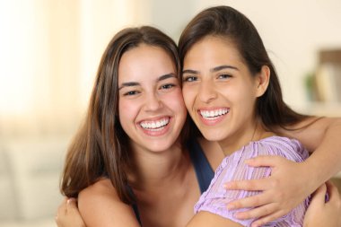 Mutlu ev arkadaşları evde kameraya gülümsüyor.